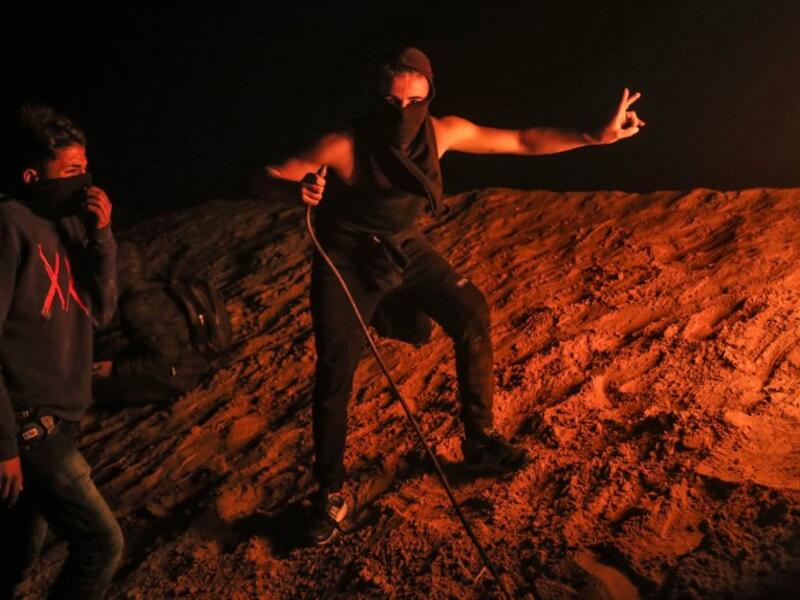 Palestinian protesters take part in a night demonstration near the fence along the border with Israel, in Rafah in the southern Gaza Strip
SAID KHATIB / AFP