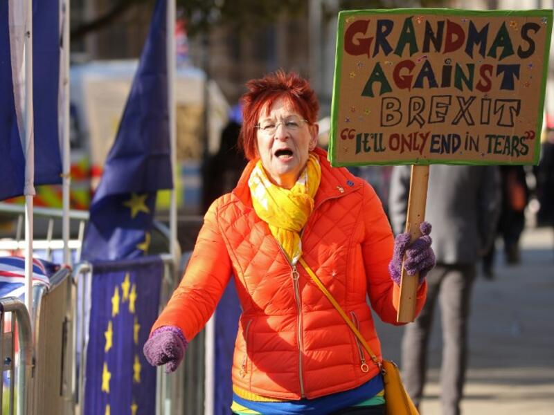 An anti-Brexit campaigner holds up a "Grandmas against Brexit" placard as she protests outside the Houses of Parliament in London (AFP)