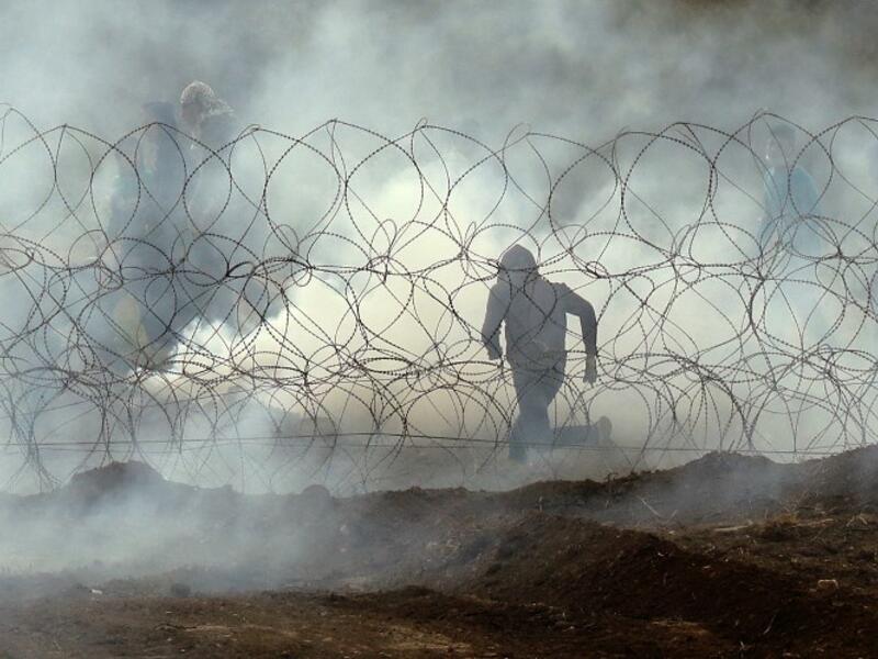Palestinian protester running away from the border fence, as Palestinians demonstrate to mark the first anniversary of the "March of Return" protests. (Jack GUEZ / AFP)