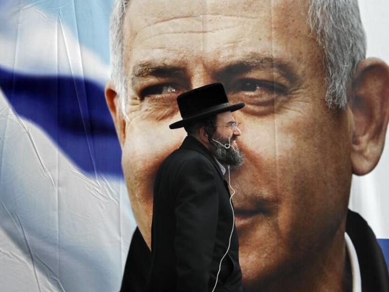 An Ultra Orthodox Jewish man walks past an electoral billboard bearing a portrait of Israel's Prime Minister Benjamin Netanyahu, in Jerusalem, on April 1, 2019. Israeli general elections will be held on April 9, 2019.
THOMAS COEX / AFP 