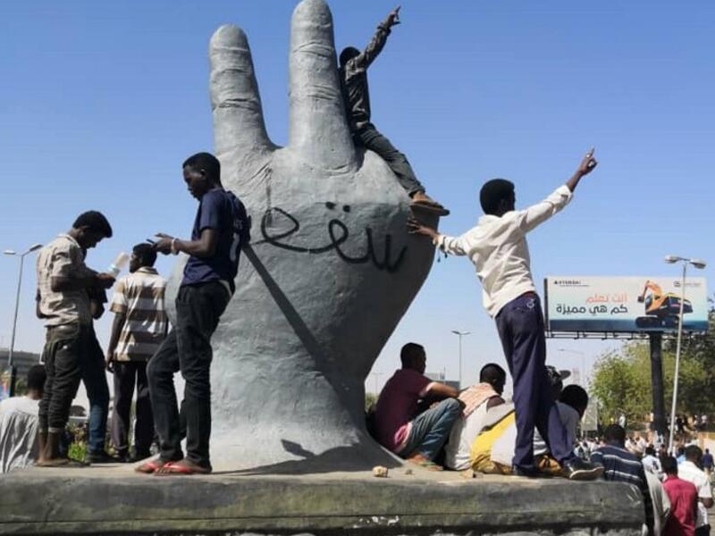 Sudanese protesters stand on a monument as others rally in the area of the military headquarters in the capital Khartoum on April 8, 2019. The writing on the monument reads in Arabic: "Victory is ours".
STRINGER / AFP
