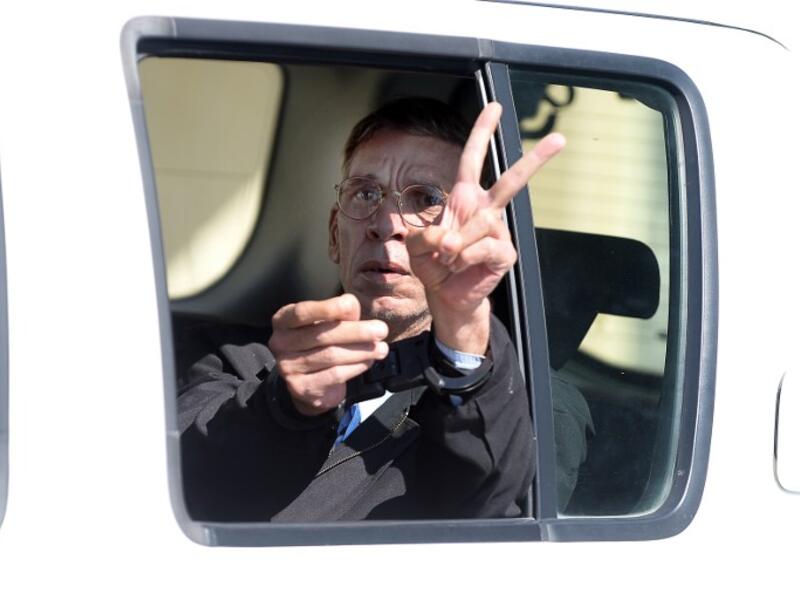 Seif al-Din Mohamed Mostafa, an Egyptian man who hijacked an EgyptAir passenger plane the previous day and forced it to divert to Cyprus demanding to see his ex-wife, flashes the "V" for victory sign as he leaves the court in Larnaca in a police car on March 30, 2016. (AFP/George Michael)
