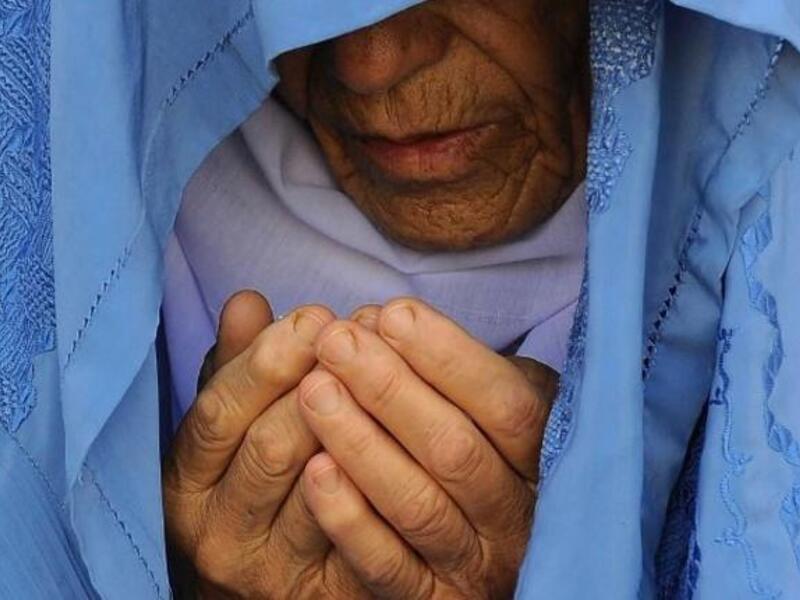 An Afghan woman prays during Eid al-Fitin Herat on August 8. (AFP)