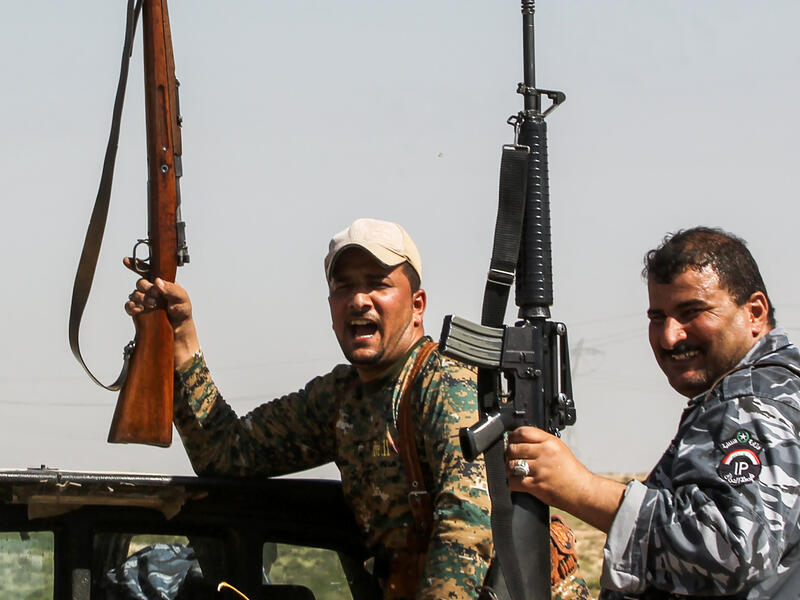 Members of the Iraqi forces pose with their rifles as they ride in the back of a pick-up truck during the advance towards villages between the northern Iraqi cities of Hawija and Kirkuk on October 6, 2017
AHMAD AL-RUBAYE / AFP