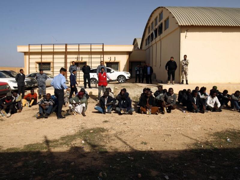 Sub-Saharan migrants sit at the Qanfouda detention center, in the southern outskirts of Benghazi, before being repatriated, on Dec. 2, 2017. 
(Abdullah DOMA / AFP)