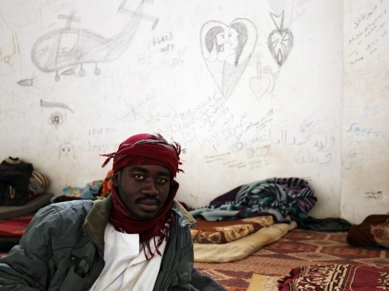 A sub-Saharan migrant sits at the Qanfouda detention center, in the southern outskirts of Benghazi, before being repatriated on Dec. 2, 2017. 
(Abdullah DOMA / AFP)