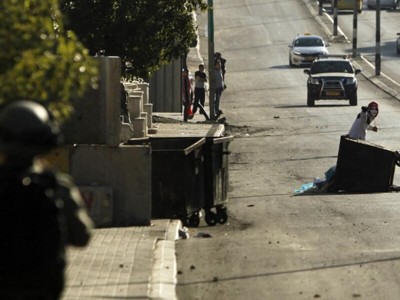 A member of the Israeli forces (L) holds a position as a Palestinian protestor throws stones during clashes following a demonstration by the Popular Front for the Liberation of Palestine (PFLP) in Bethlehem in the Israeli occupied West Bank. 
(Musa AL SHAER / AFP)