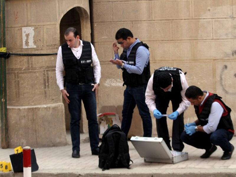 Egyptian security members and forensic police inspect the site of a gun attack outside a church south of the capital Cairo, on Dec. 29, 2017. A gunman opened fire on a church, killing at least nine people before policemen shot him dead, state media and officials said. 
(STRINGER / AFP)
