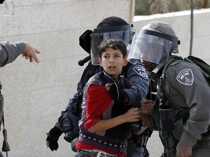 Israeli soldiers detain a Palestinian boy during a protest in the Aida refugee camp, near Bethlehem in the West Bank. (AFP/File)