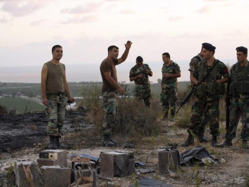 Lebanese soldiers stand next to the remains of an Israeli spy device on September 5, 2014 near the village of Adloun in southern Lebanon. (AFP/Mahmoud Zayyat)