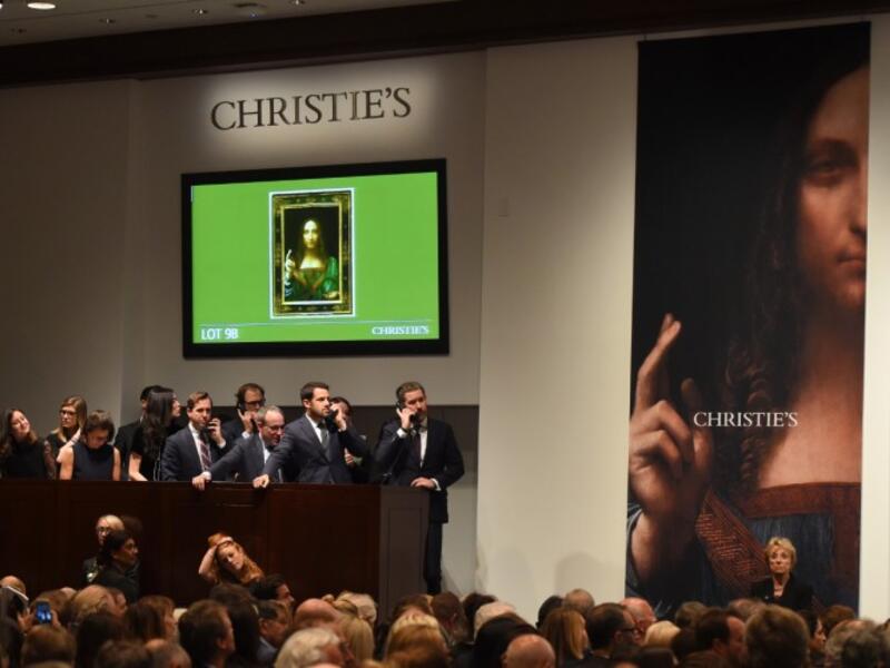 Christie's employees take bids for Leonardo da Vinci’s 'Salvator Mundi' at Christie's New York November 15, 2017. A 500-year-old work of art depicting Jesus Christ sold in New York on Wednesday for $450.3 million setting a new art auction record. (AFP/Timothy A. Clary)