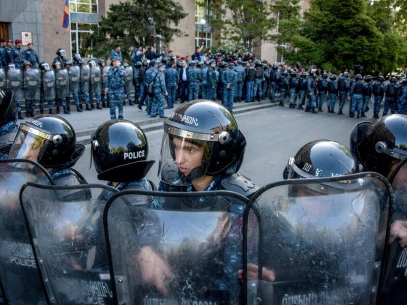 Riot police stand guard in front of the entrance to government headquarters which protestors tried to enter (AFP/File Photo) 