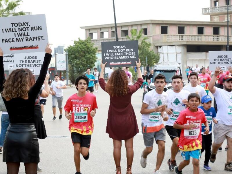 Activists hold banners against sexual assaults during the 16th edition of the Beirut Marathon on November 11, 2018. 
ANWAR AMRO / AFP