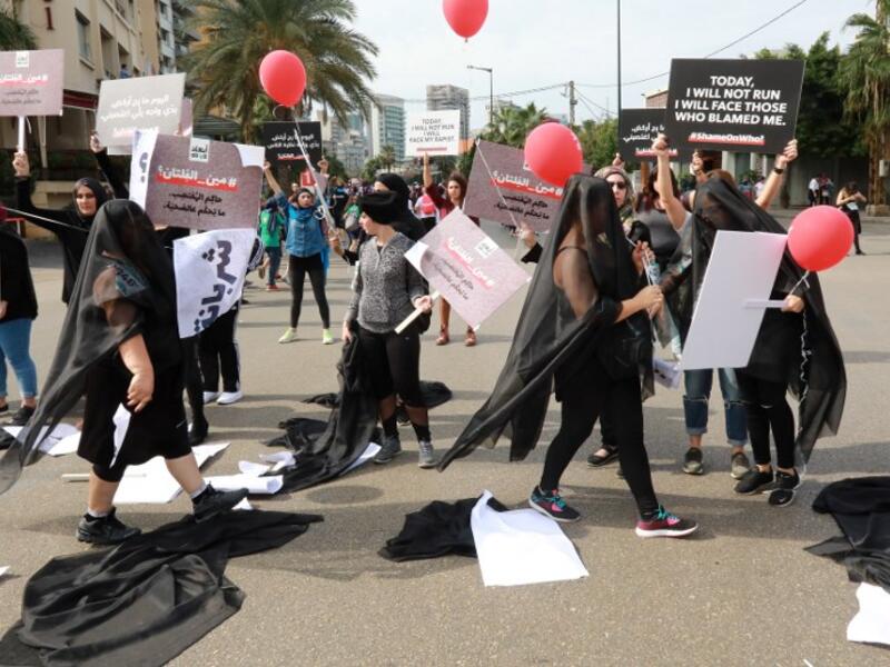 Activists hold banners against sexual assaults during the 16th edition of the Beirut Marathon on November 11, 2018. 
ANWAR AMRO / AFP