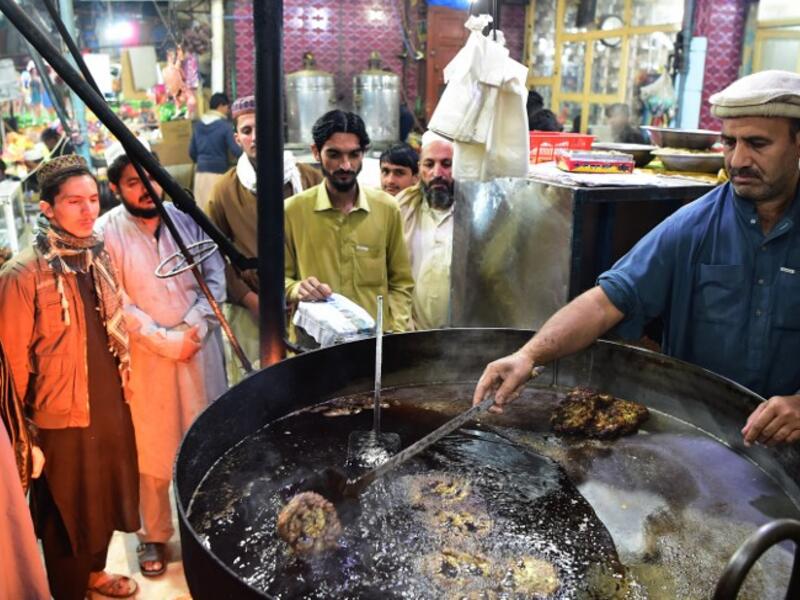  Pakistani cook grills kebabs while customers look on at the Tory Kebab House in Namak Mandi in Peshawar.
ABDUL MAJEED / AFP