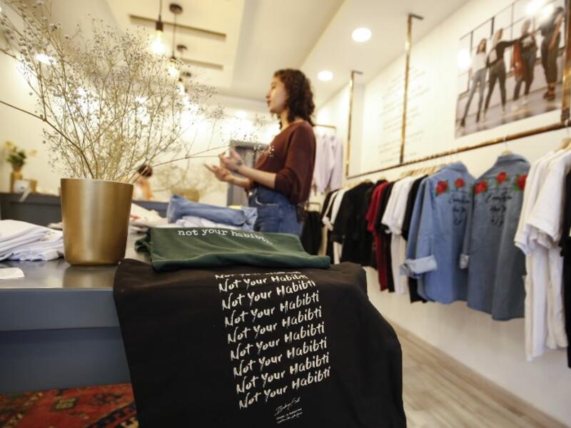 Palestinian fashion designer Yasmeen Mjalli speaks while standing in her clothing shop where her label collection "BabyFist" carrying anti-sexual harassment slogans is showcased, in Ramallah in the occupied West Bank 
ABBAS MOMANI / AFP
