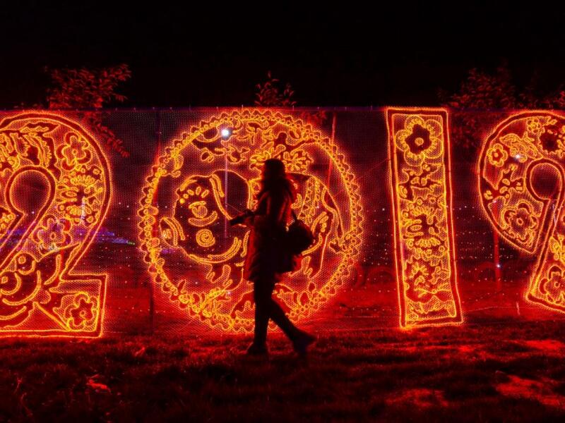 This photo taken on December 20, 2018 shows a woman walking past illuminated decorations at a lighting display in Handan in China's northern Hebei province. 
STR / AFP