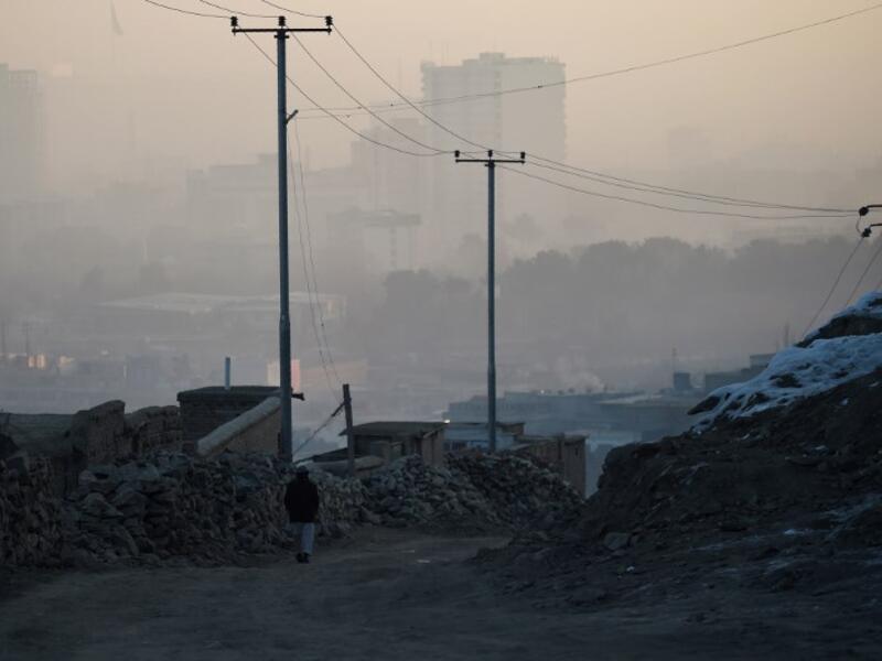 In this photograph an Afghan resident walks along a dirt path amid heavy smog conditions in Afghanistan's capital Kabul. 
WAKIL KOHSAR / AFP
