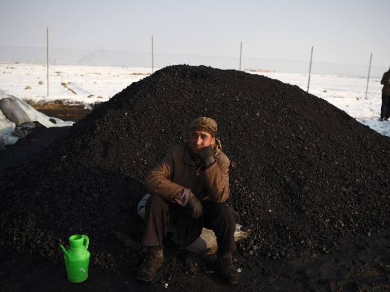 In this picture, an Afghan day labourer sits next to a pile of coal at a coal yard amid heavy smog conditions in the outskirts of Kabul. 
WAKIL KOHSAR / AFP