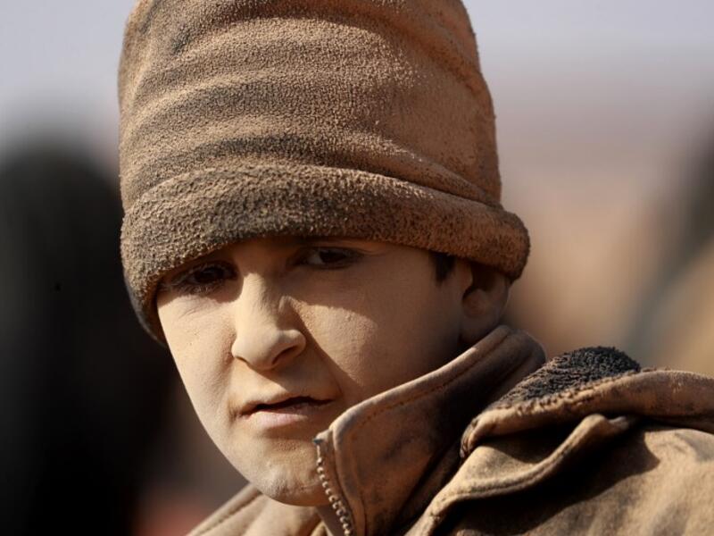 A young boy covered in dust is ppictured as people who fled battles between Syrian Democratic Forces (SDF) and ISIS fighters in the Syrian village of Baghouz, arrive after crossing a desert in the back of a truck to a region controlled by the SFD in the countryside of the Deir Ezzor province  Delil SOULEIMAN / AFP