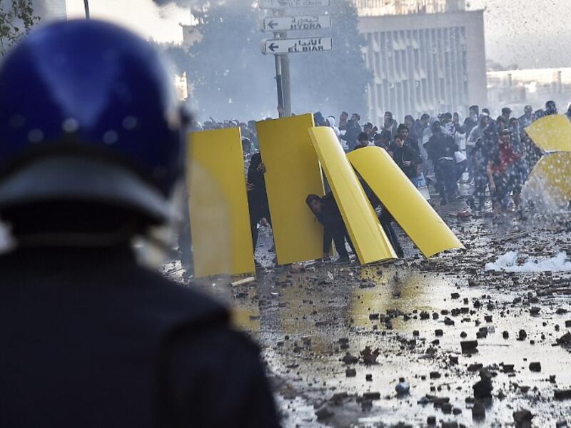 Algerian protesters use makeshift barriers during clashes with security forces amidst protests against ailing President Abdelaziz Bouteflika's bid for a fifth term in power in the capital 
RYAD KRAMDI / AFP