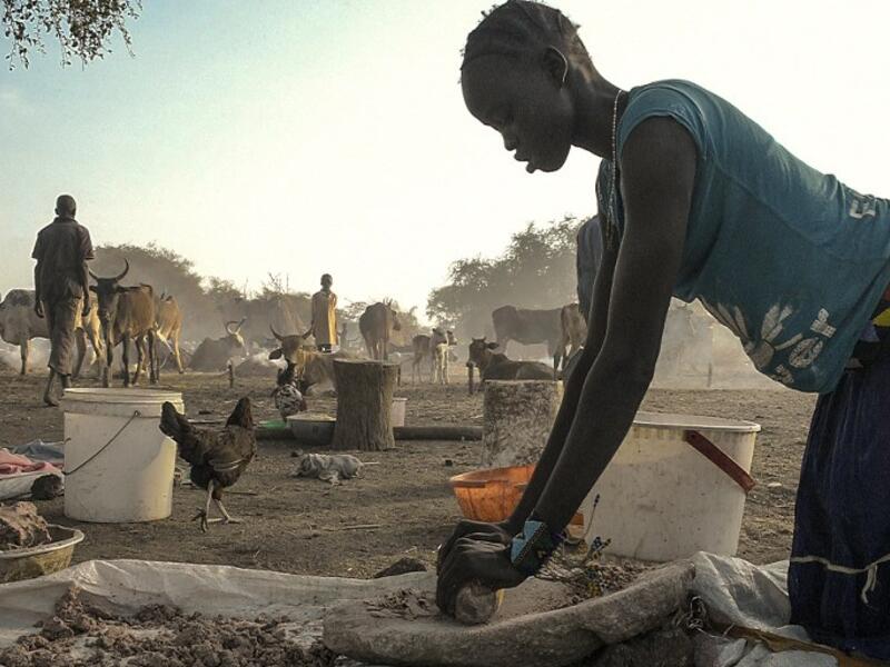 A woman grinds traditional millet, ahead of cattle vaccinations administered by the International Committee of the Red Cross (ICRC) with the help of local community workers, at Kirgui village in Udier, South Sudan 
SIMON MAINA / AFP