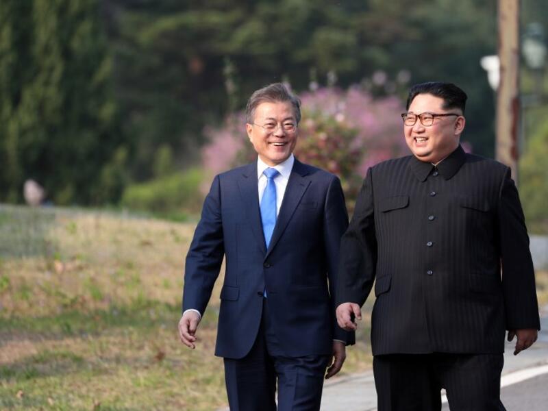 North Korea's leader Kim Jong Un (R) and South Korea's President Moon Jae-in (L) walk together after a tree-planting ceremony. Korea Summit Press Pool / AFP
