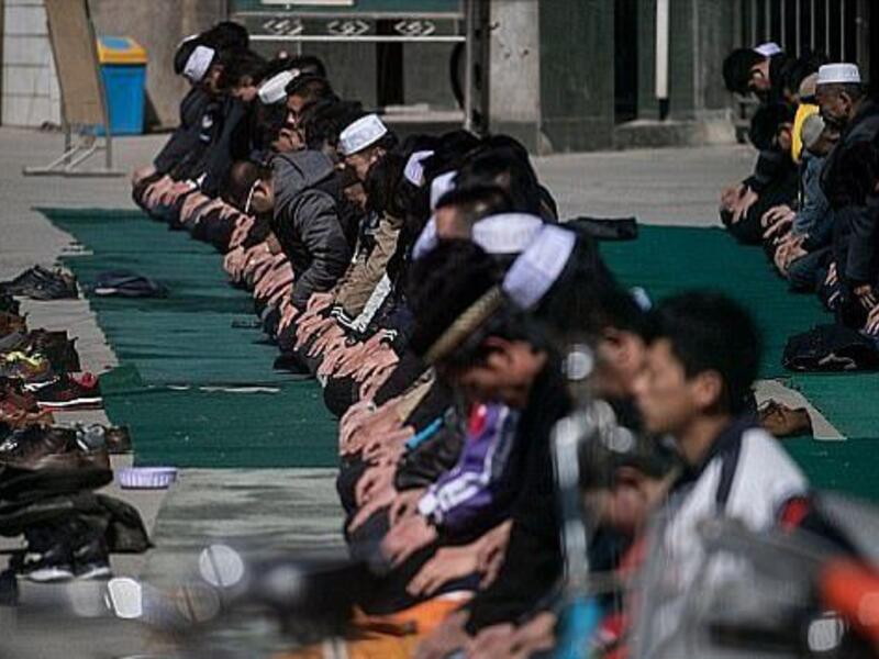Ethnic Hui Muslim men praying at Nanguan Mosque during Friday prayers in Linxia, Gansu (AFP)