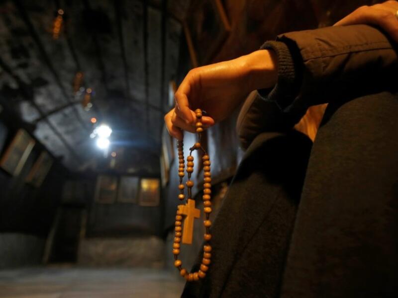 A Christian worhsipper prays inside the Grotto, believed to be the exact spot where Jesus Christ was born, at the Church of the Nativity in the biblical West Bank city of Bethlehem, on December 22, 2018, three days ahead of the Christmas celebration. 
Musa AL SHAER / AFP