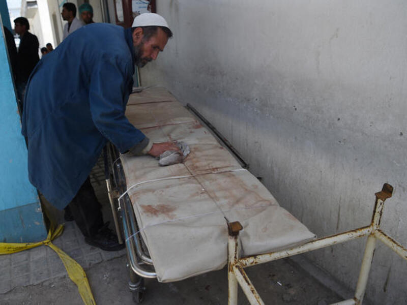 An Afghan medical staff member cleans a stretcher following a suicide bombing attack in Kabul on April 22, 2018. (AFP Photo/ Wakil Kohsar)