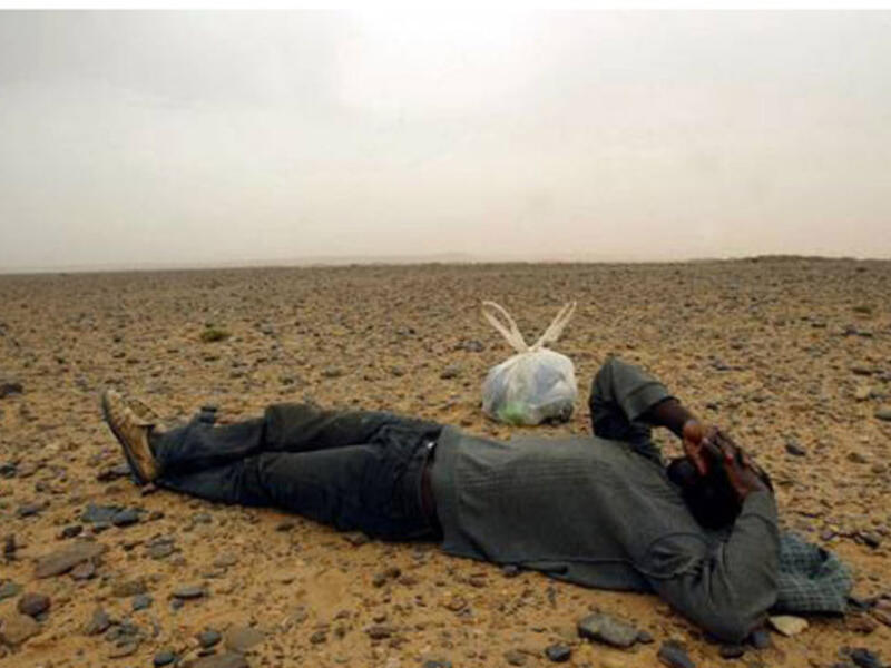 A travelling migrant resting in the middle of the Sahara Desert, near the border with Algeria. (AFP/ File Photo)