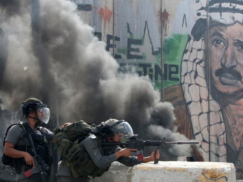 Israeli soldiers clash with Palestinian stone throwers at a checkpoint outside Jerusalem (AFP/Getty Images/ Ahmad Gharabli)