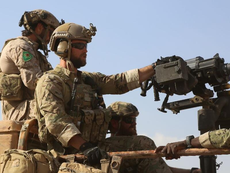 Armed men in uniform identified by Syrian Democratic forces as US special operations forces ride in the back of a pickup truck in the northern Syrian province of Raqa on May 25, 2016. (AFP/File) 