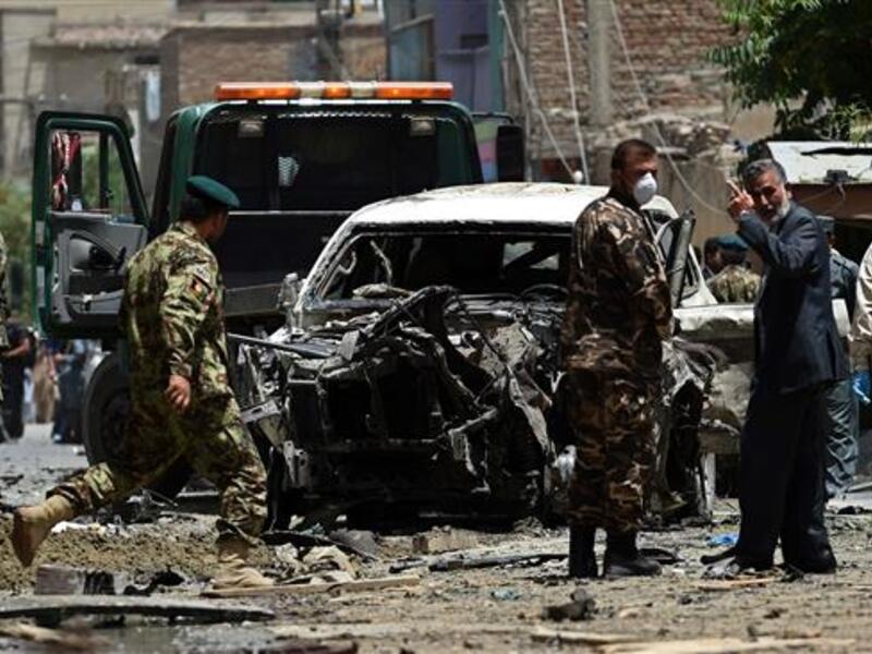 Afghan security forces inspect a damaged vehicle at the site of a bombing in the capital city of Kabul, July 7, 2015. (AFP/File) 