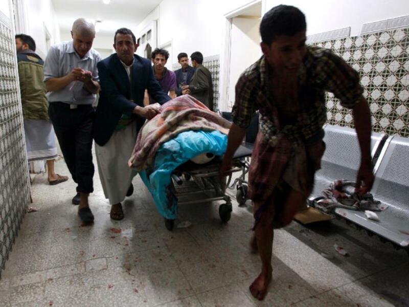 Yemenis transport a severely injured man on a gurney as he arrives at a hospital in Sanaa after being injured when two suicide bombers hit a Shiite mosque in quick succession, September 2, 2015. (AFP/Mohammed Huwais)