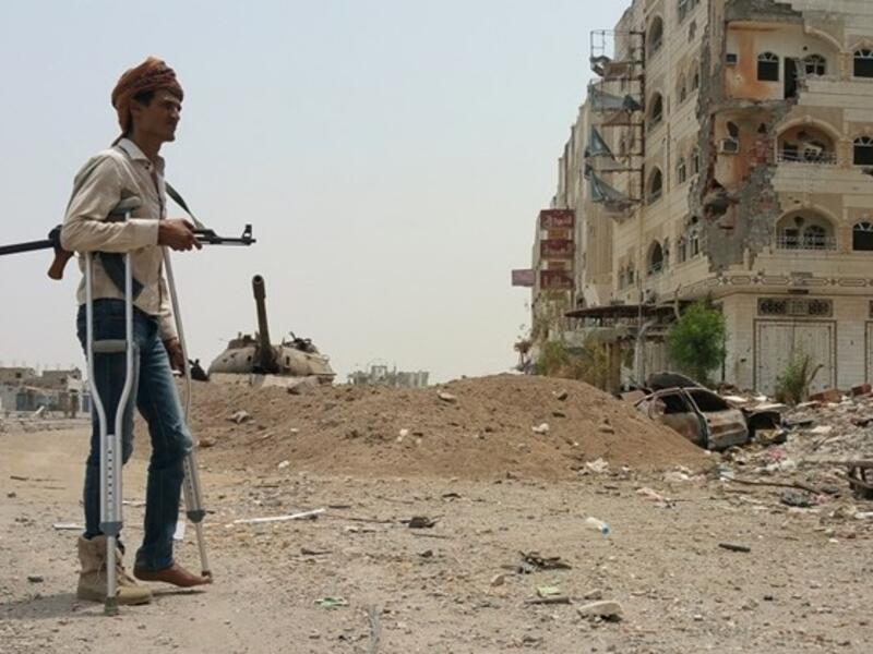 A fighter loyal to Yemen's exiled President Abedrabbo Mansour Hadi walks with crutches in Yemen's second city of Aden on July 30, 2015. (AFP/File) 