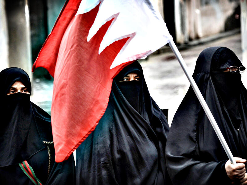 Bahraini activists holding the national flag. (AFP/File)