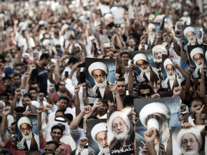 Bahraini protestors shout slogans and hold up pictures of Bahraini top senior shiite cleric, Sheikh Isa Qassim, during an anti-government rally to support Qassim in the village of Diraz, west of the capital Manama, on May 24 (Mohammed Al-Shaikh/ AFP)