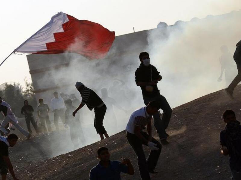 Bahraini protesters clash with police as they are sprayed with tear gas. [AFP]
