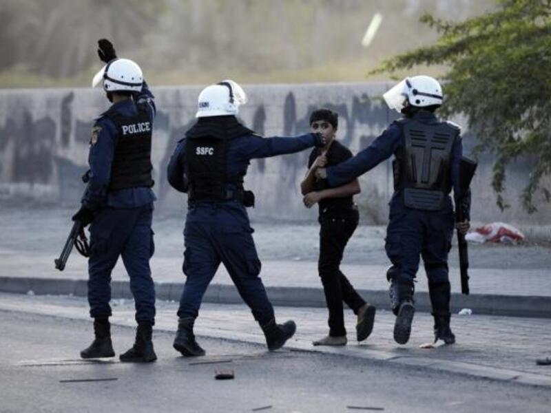 Bahraini police officers escort a child away from the scene of demonstrations in 2015. (AFP/File)