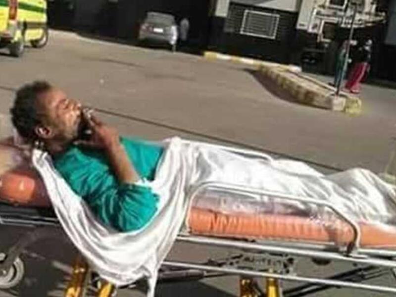 widespread photos of a patient who was allowed to smoke a cigarette, while being moved in a trolley on hospital grounds in Egypt. (Twitter)