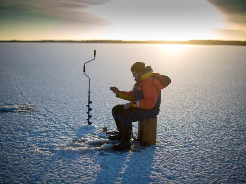 A man is ice-fishing at midday on the frozen Bothnia Sea, on December 28, 2016 in Vaasa, Western Finland. (OLIVIER MORIN/ AFP)