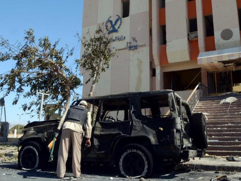 An Egyptian policeman inspects the wreckage after a car bomb blast kills three policemen in al-Tur, in the Sinai peninsula, on October 7, 2013 (AFP/Mohamed el-Shahed)