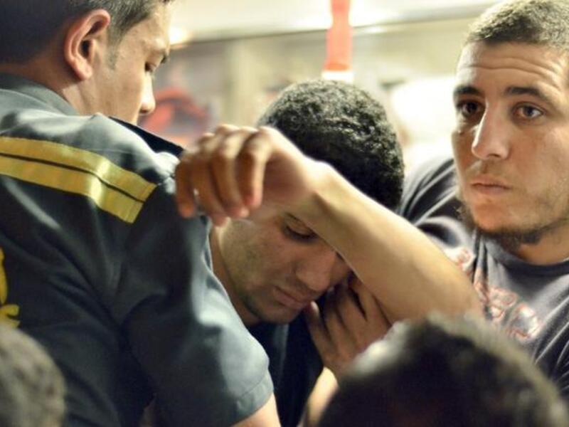 A student suffering from food poisoning is helped into an ambulance (AFP Photo/ Mohammed Al Shahed)