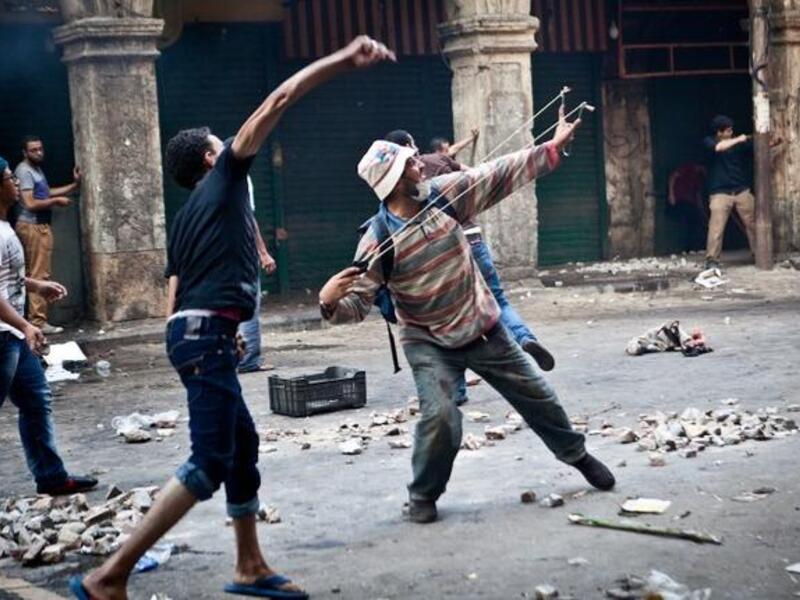 EGYPT, Cairo : Supporters of ousted president Mohamed Morsi throw stones as they clash with security officers in Cairo's Ramses Square, on August 16, 2013. AFP PHOTO / VIRGNIE NGUYEN HOANG