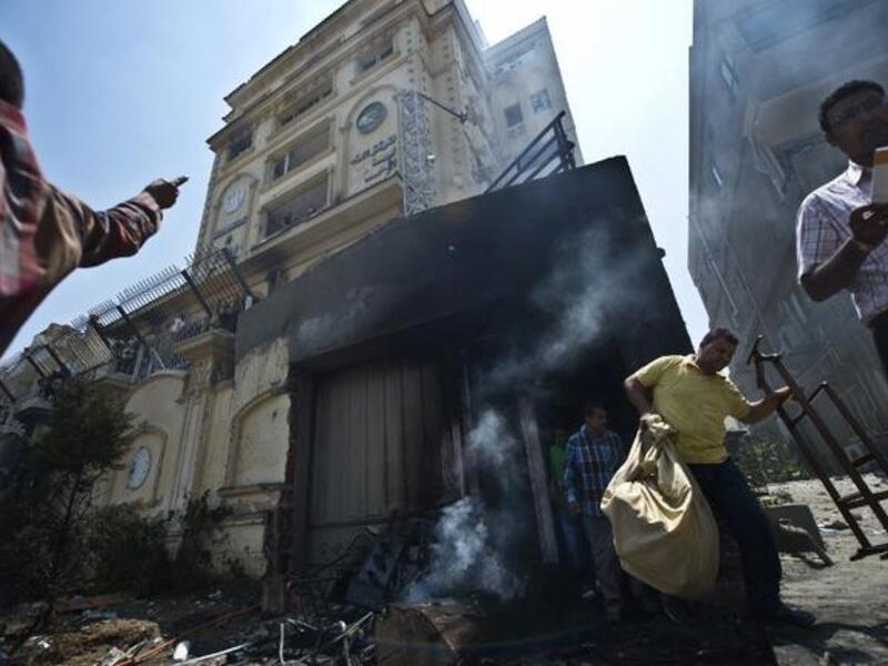 Egyptian men carry items looted from the burnt headquarters of the Muslim Brotherhood (Khaled Desouki / AFP)