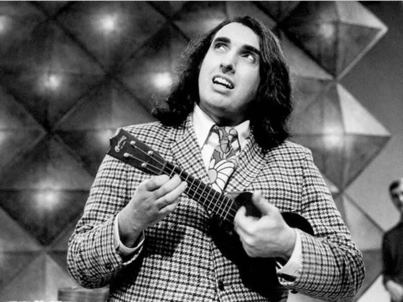 a
Lebanese-American folk singer "Tiny Tim" (born Herbert Khaury in 1932) was a ukulele player most famous for his version of "Tiptoe Through the Tulips" sung in a high falsetto voice. He famously got married on Johnny  Carson’s Tonight Show in 1969. See him on YouTube — he could be Russell Brand’s dad!

