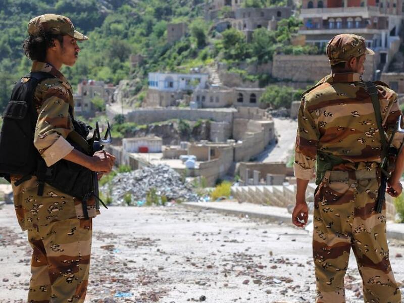 Fighters survey the ongoing damage in the Taez province. (AFP/Ahmad al-Basha)