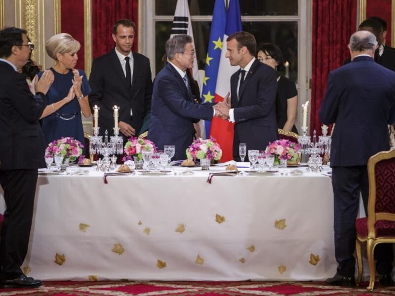 French President Emmanuel Macron (C-R), his wife Brigitte Macron (L), South Korean President Moon Jae-in (C-L) and his wife Kim Jung-sook (R) toast during a state dinner at the Elysee Presidential palace in Paris, on October 15, 2018. (Christophe Petit-Tesson / POOL / AFP)