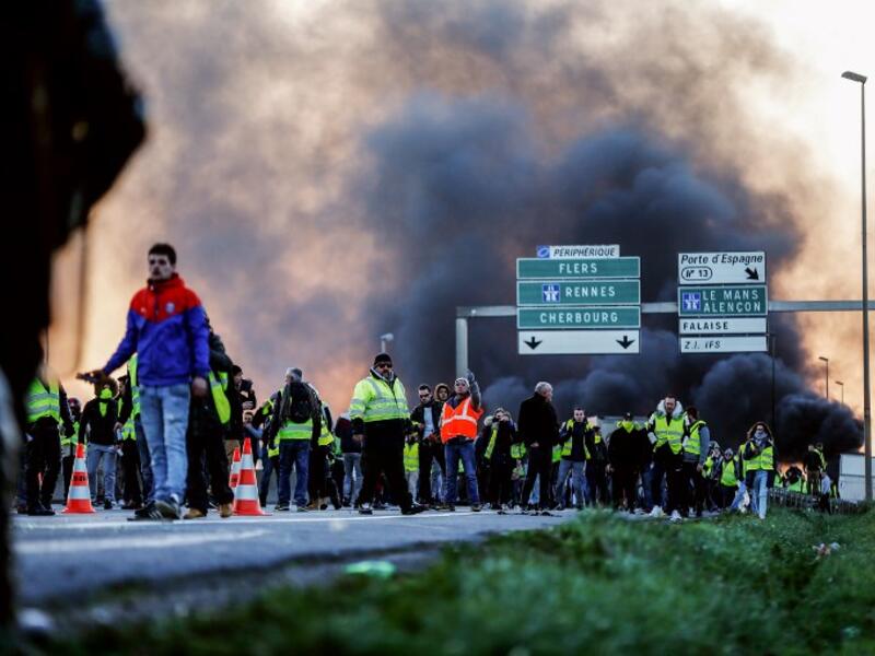 People stand in front of gendarmes on Caen's circular road on November 18, 2018 in Caen.
CHARLY TRIBALLEAU / AFP